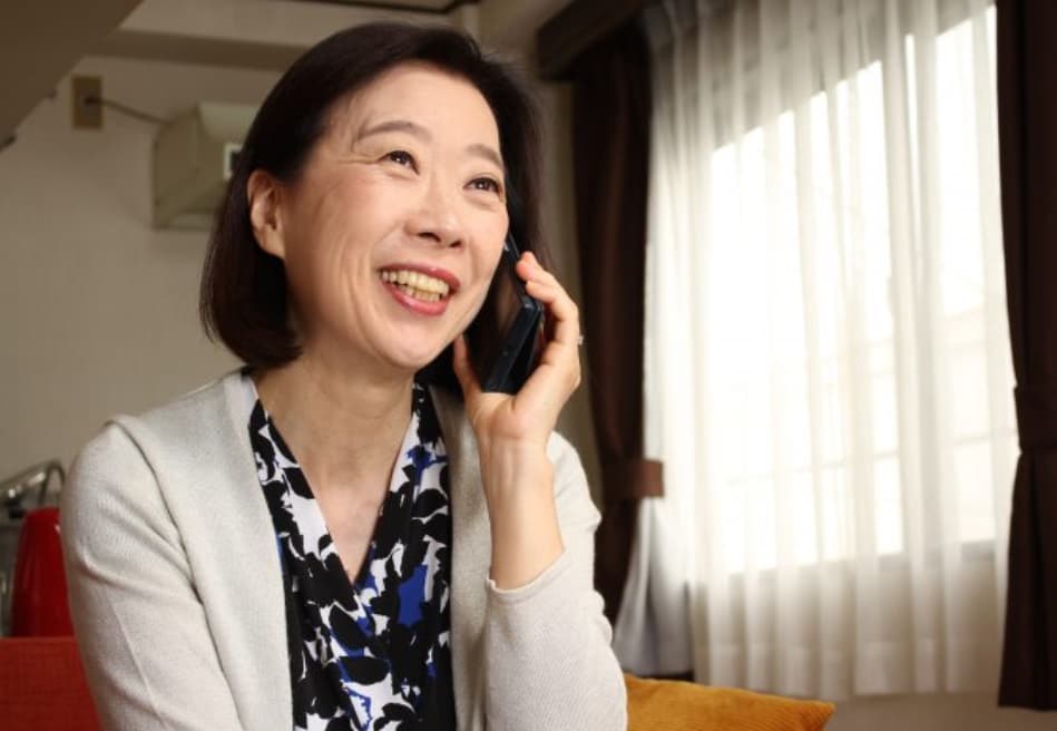 スマートフォンでご相談され笑顔のお客様